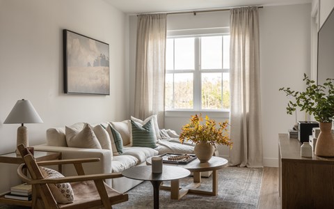 A living room with a couch, chair, and a painting on the wall.